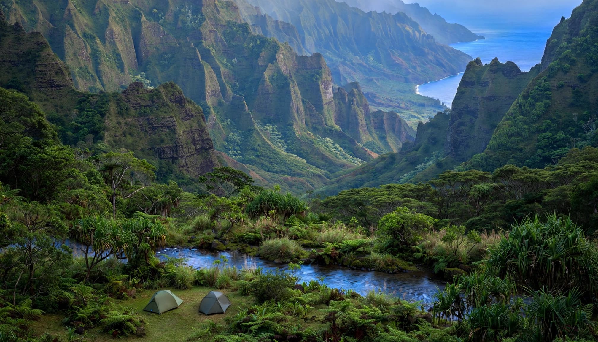 Two small tents sit in a grassy clearing beneath green cliffs near a stream.